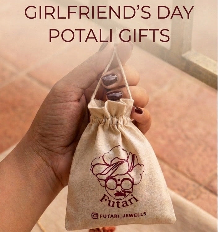 A hand holds a small beige drawstring pouch printed with a stylized face logo and the text 'Futari' and 'FUTARI JEWELLS'. Large overlaid text at the top reads 'GIRLFRIEND'S DAY POTALI GIFTS'.