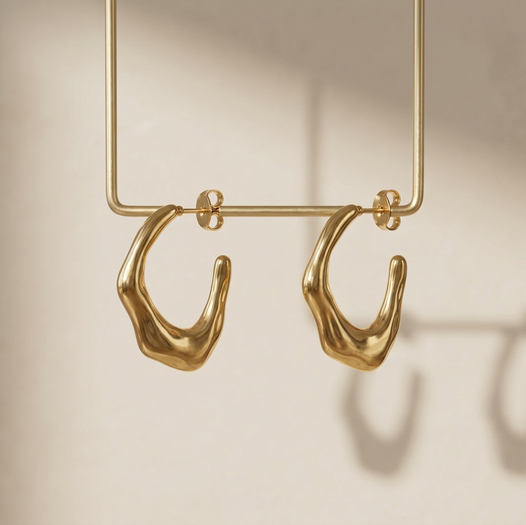 Gold hoop earrings on a beige background