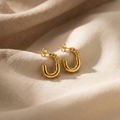 Gold hoop earrings on a beige fabric background