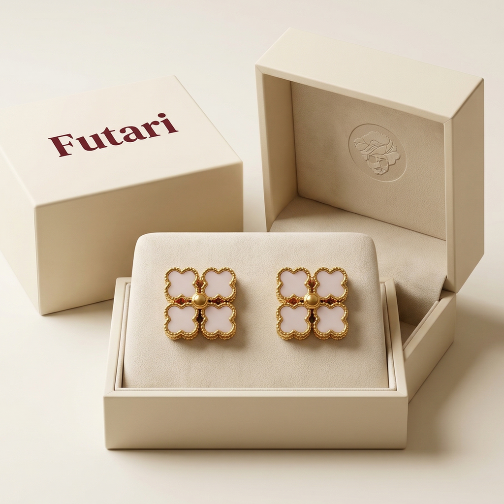 Gold and white earrings in an open jewelry box with 'Futari' branding.