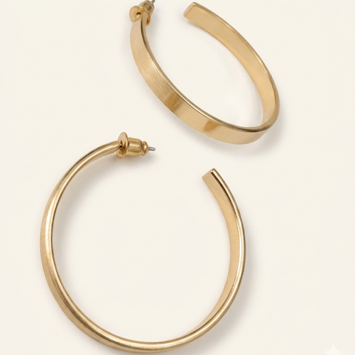 Gold hoop earrings on a light beige background