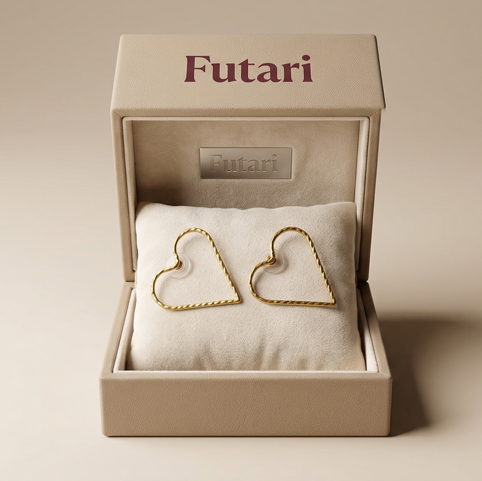 Heart-shaped gold earrings in a 'Futari' box on a beige background