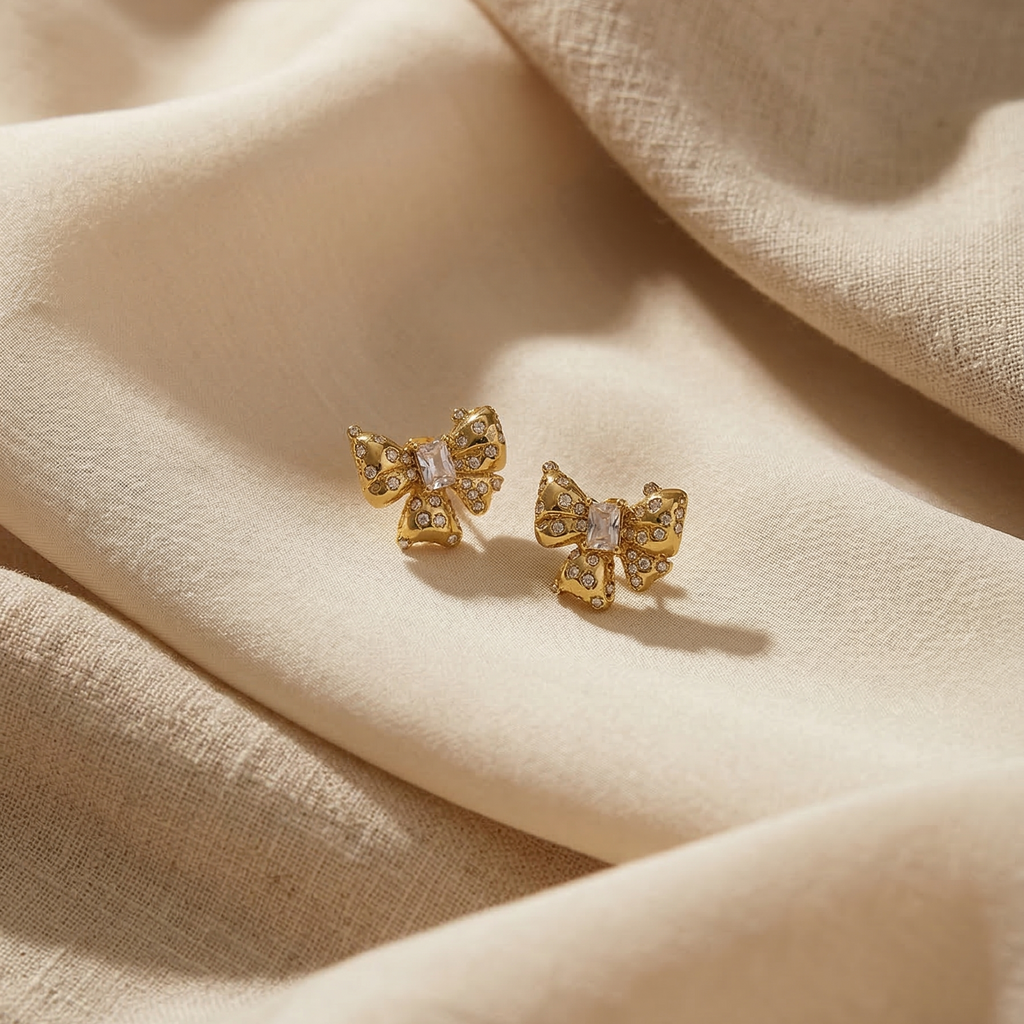 Gold butterfly earrings on beige fabric
