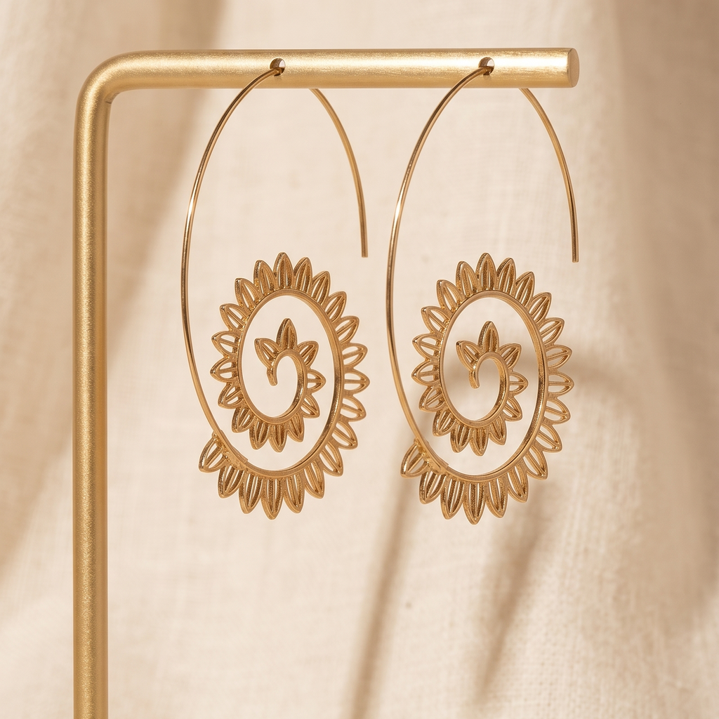 Gold hoop earrings with floral designs on a beige background