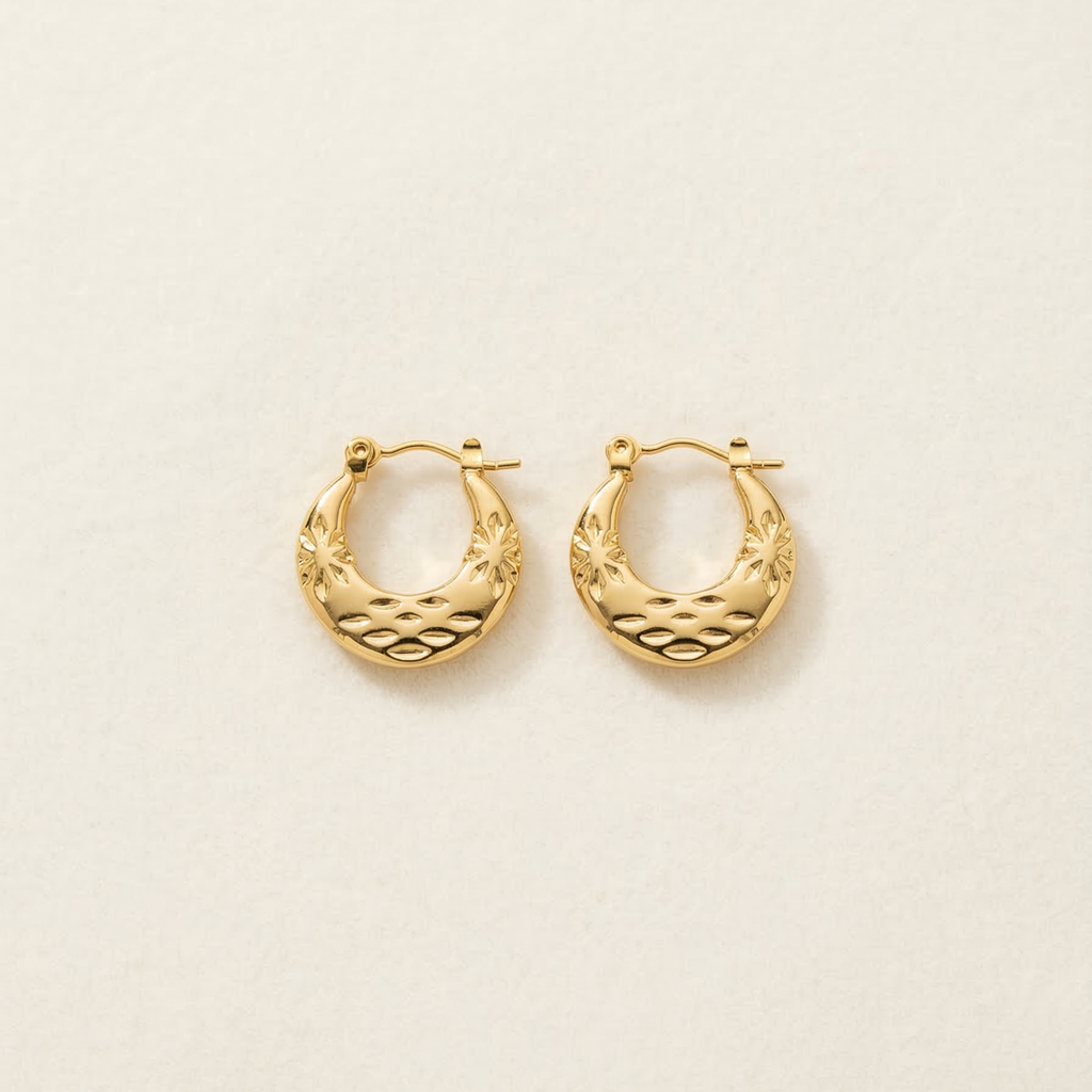Gold hoop earrings on a light beige background