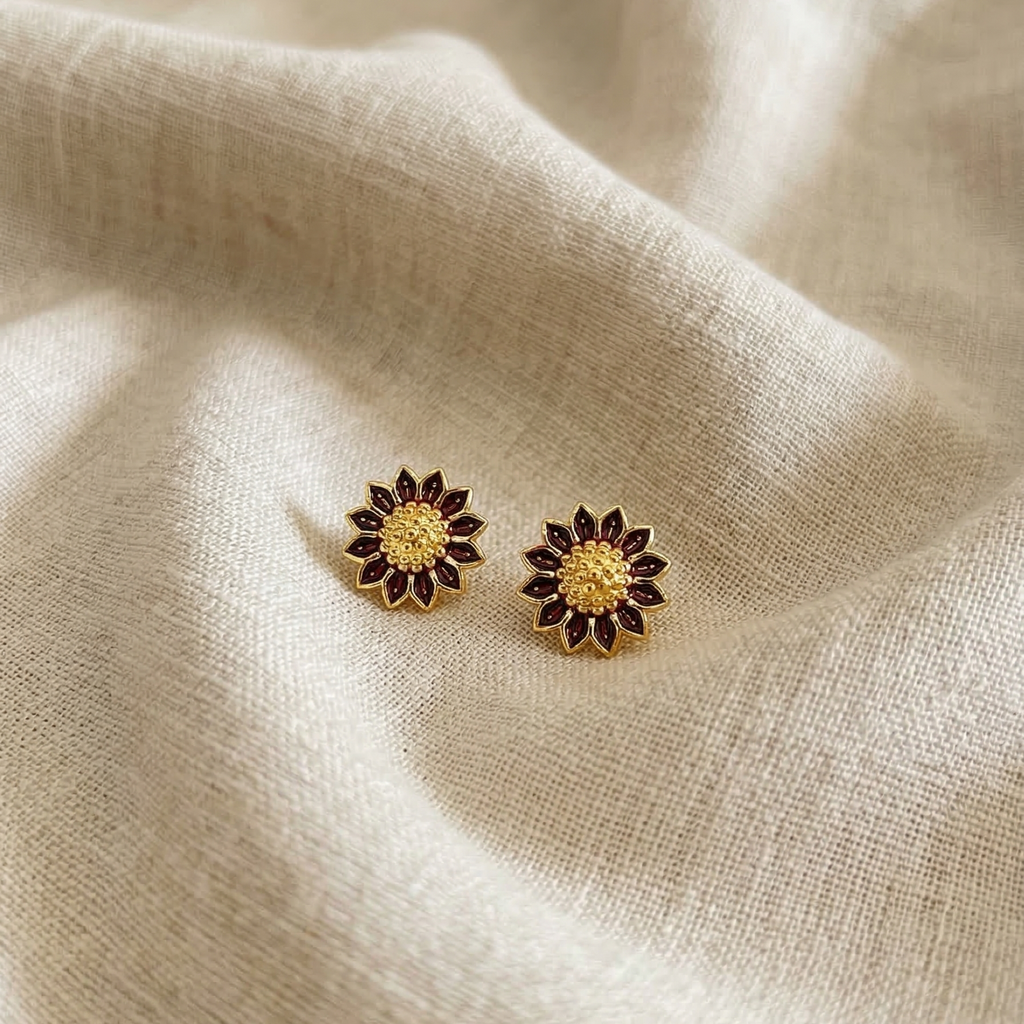 Pair of sunflower-shaped earrings on a beige fabric background