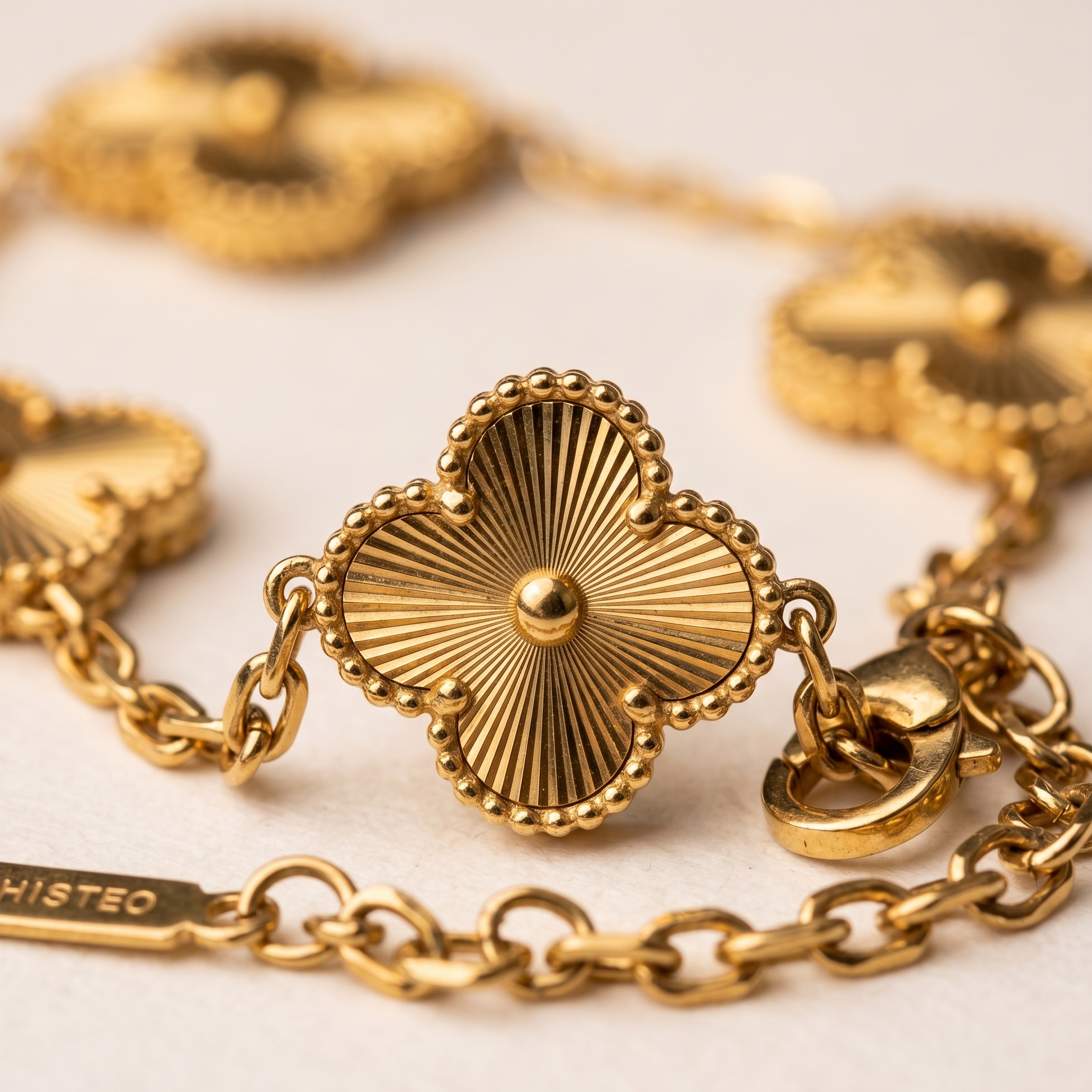 Gold chain bracelet with intricate heart-shaped clasp on a light background