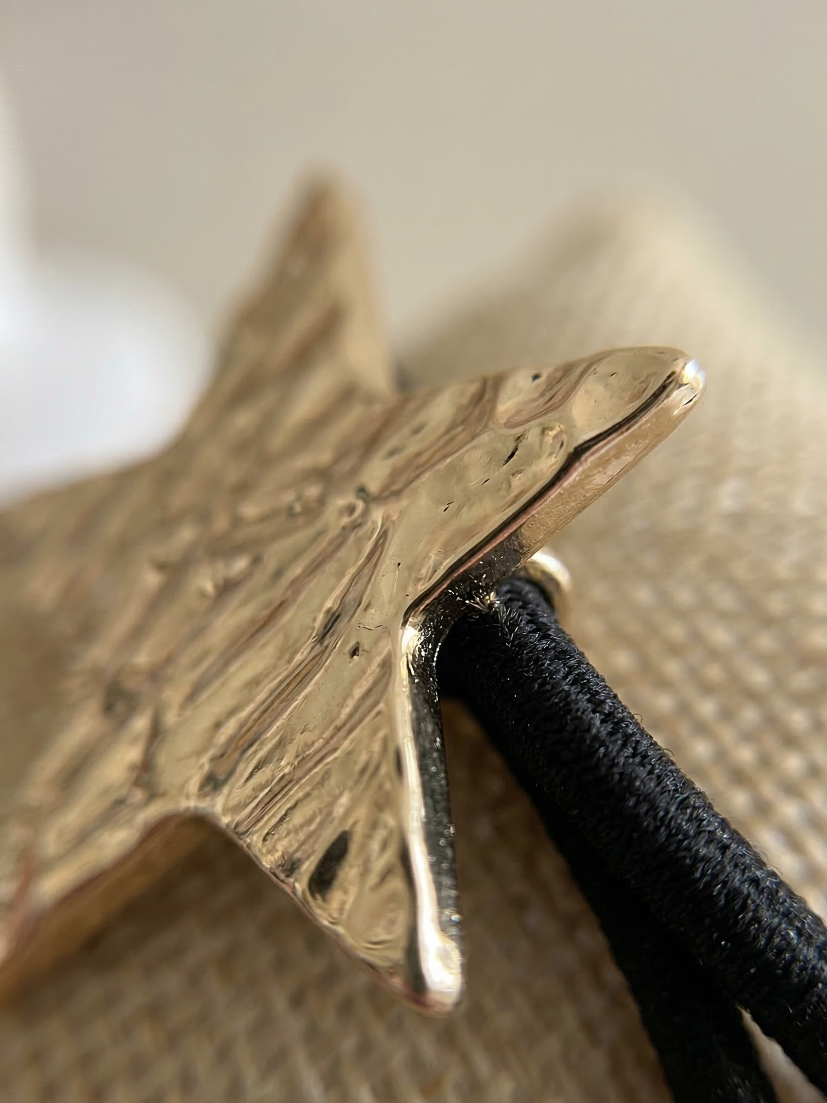 Gold star-shaped hair clip on a textured surface