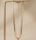 Gold necklace on a beige background