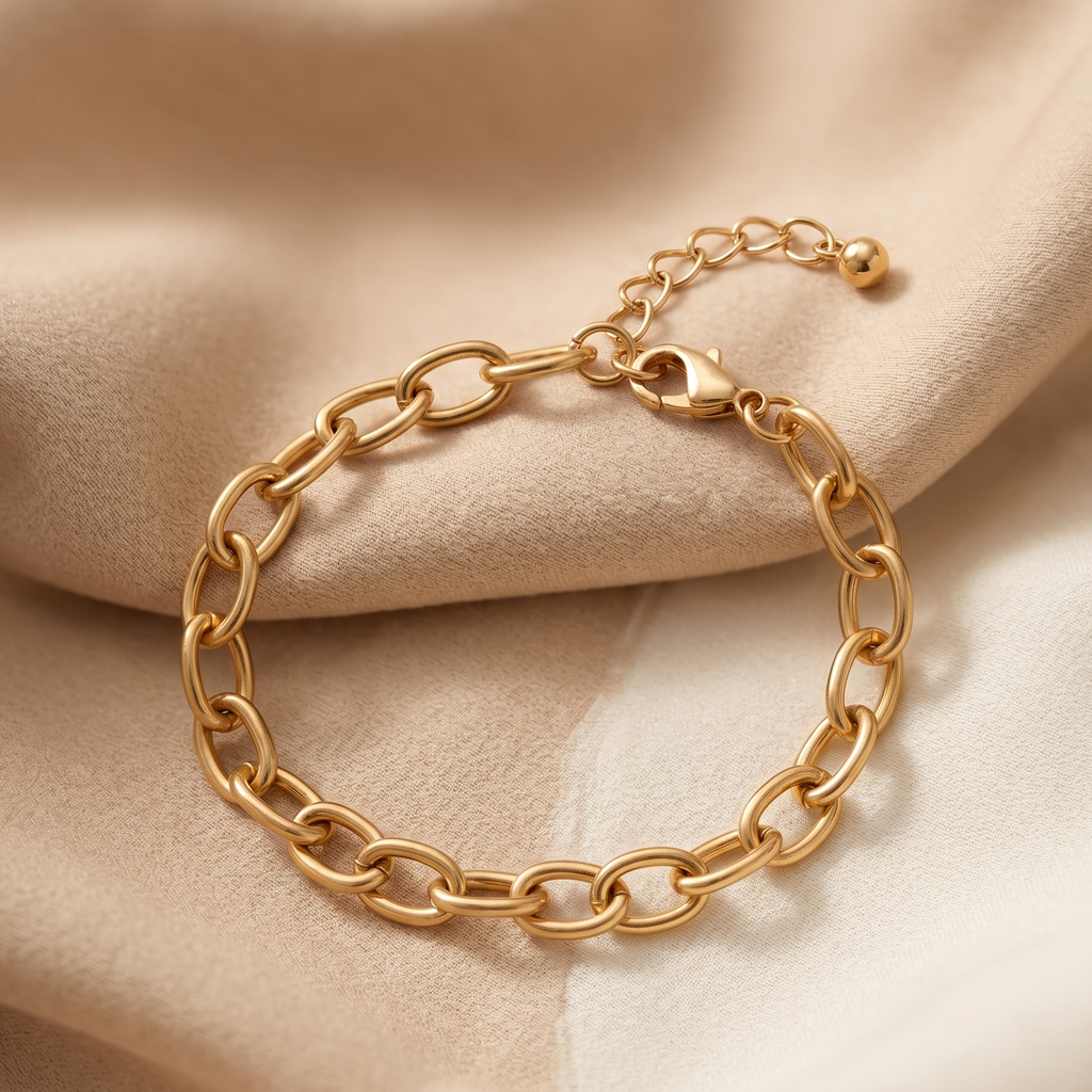 Gold chain bracelet on a beige fabric background