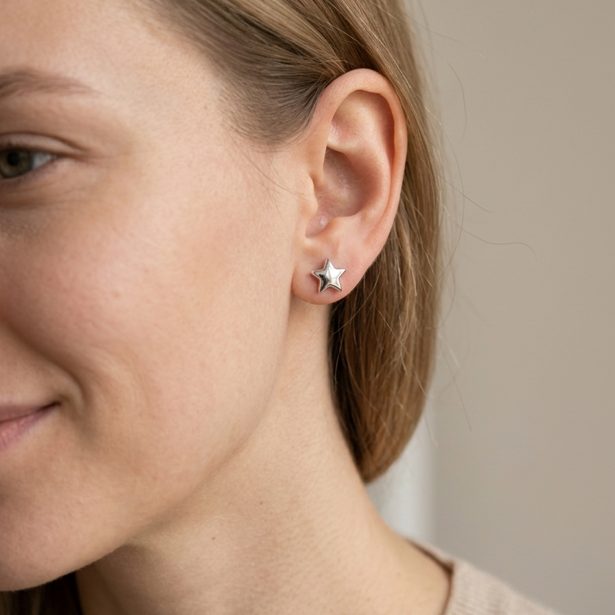 Close-up of a person wearing a star-shaped earring with a neutral background