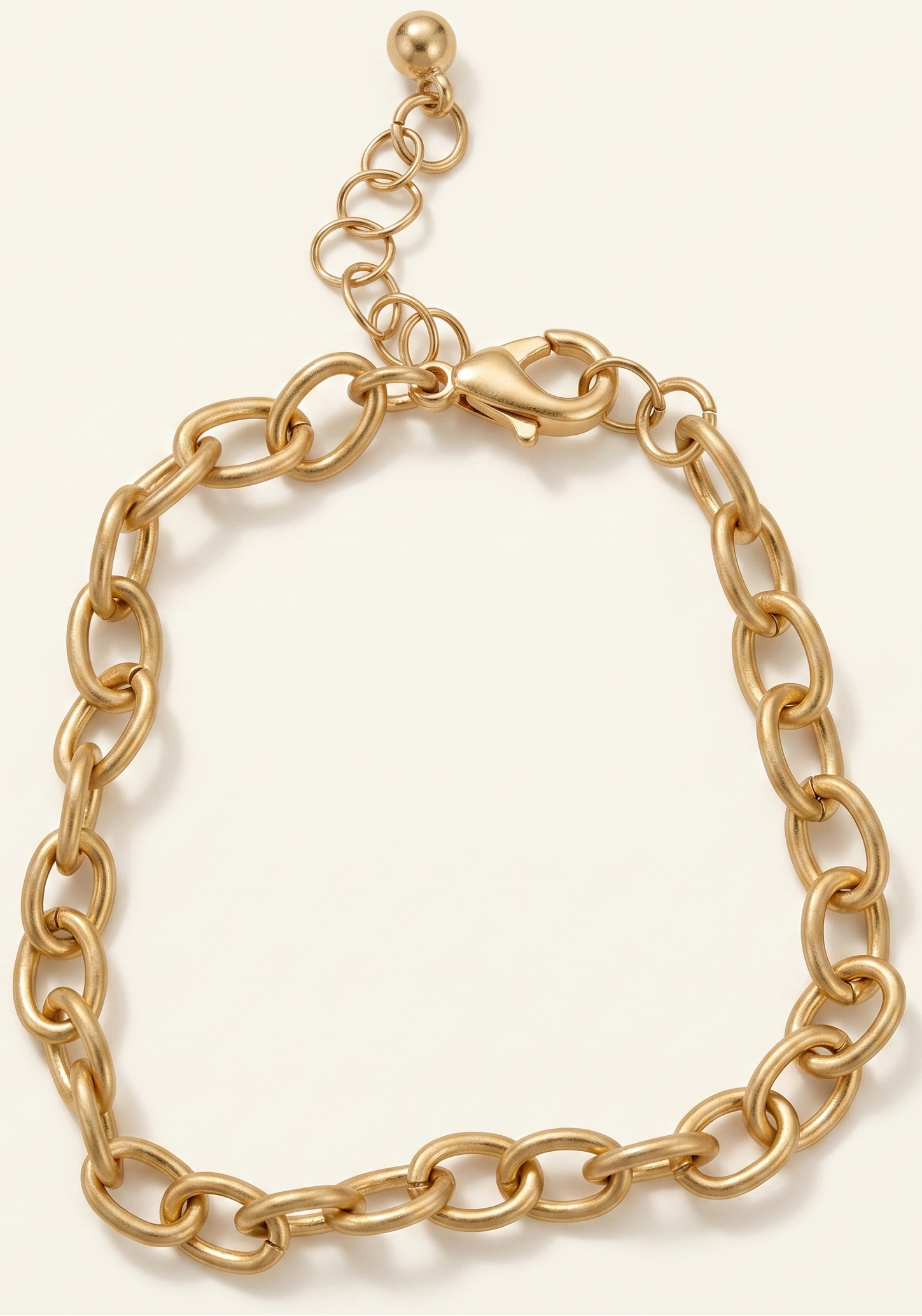 Gold chain bracelet on a light beige background