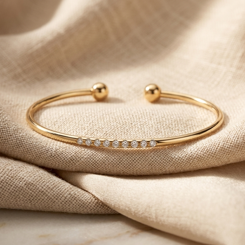 Gold bracelet with small diamonds on beige fabric