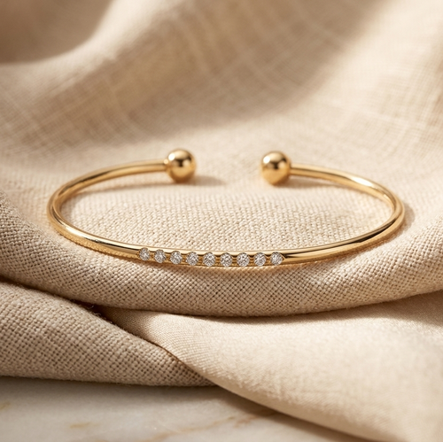 Gold bracelet with small diamonds on beige fabric