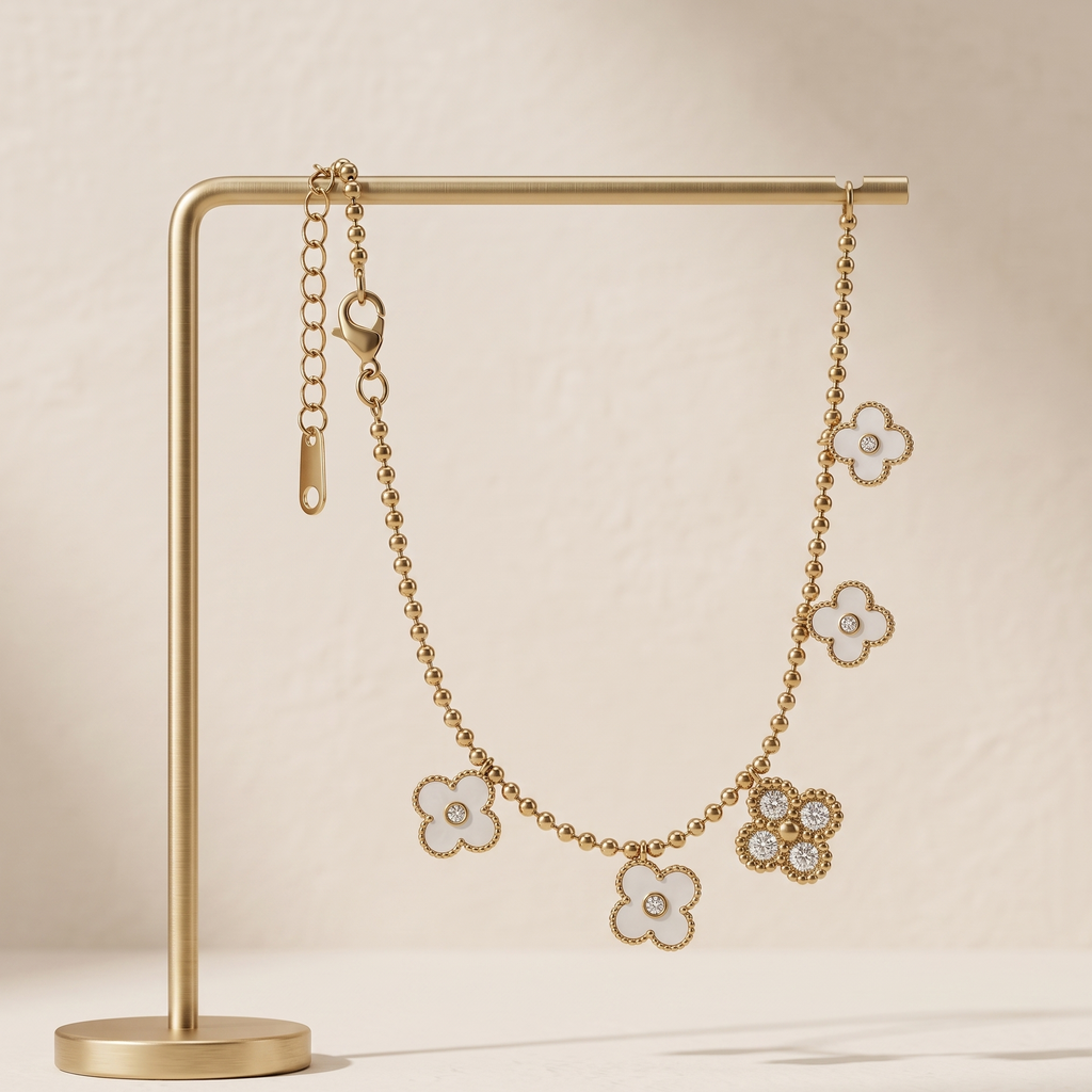 Gold floral earrings on a gold stand against a beige background