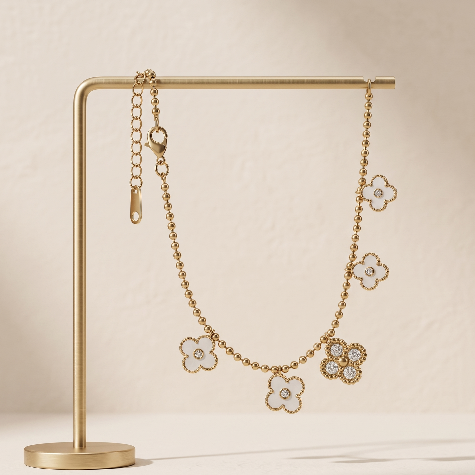 Gold floral earrings on a gold stand against a beige background