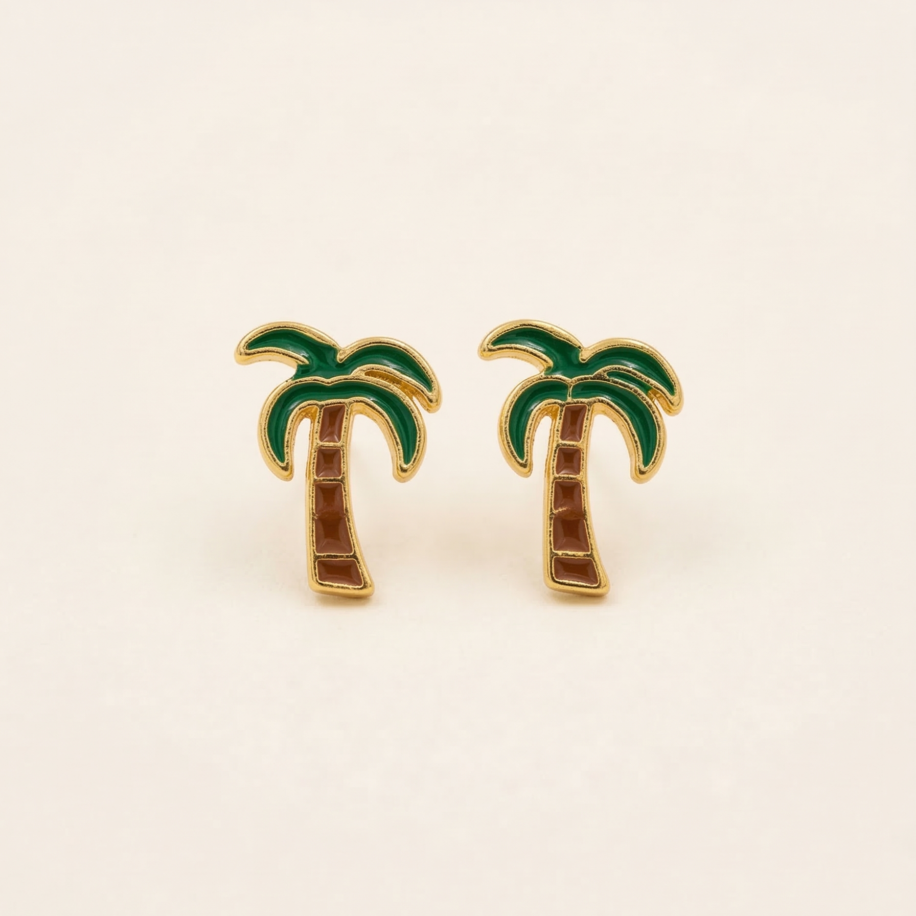 Palm tree earrings on a beige background
