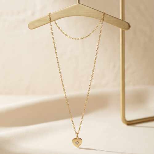 Gold necklace with a heart pendant on a beige background
