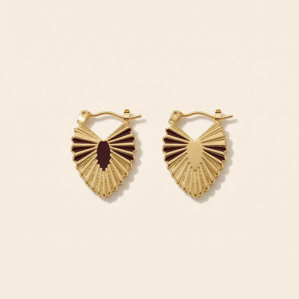 Gold heart-shaped earrings on a beige background