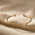Gold bracelet on a beige fabric background