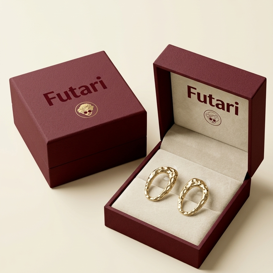 Gold hoop earrings in an open Futari jewelry box on a beige background