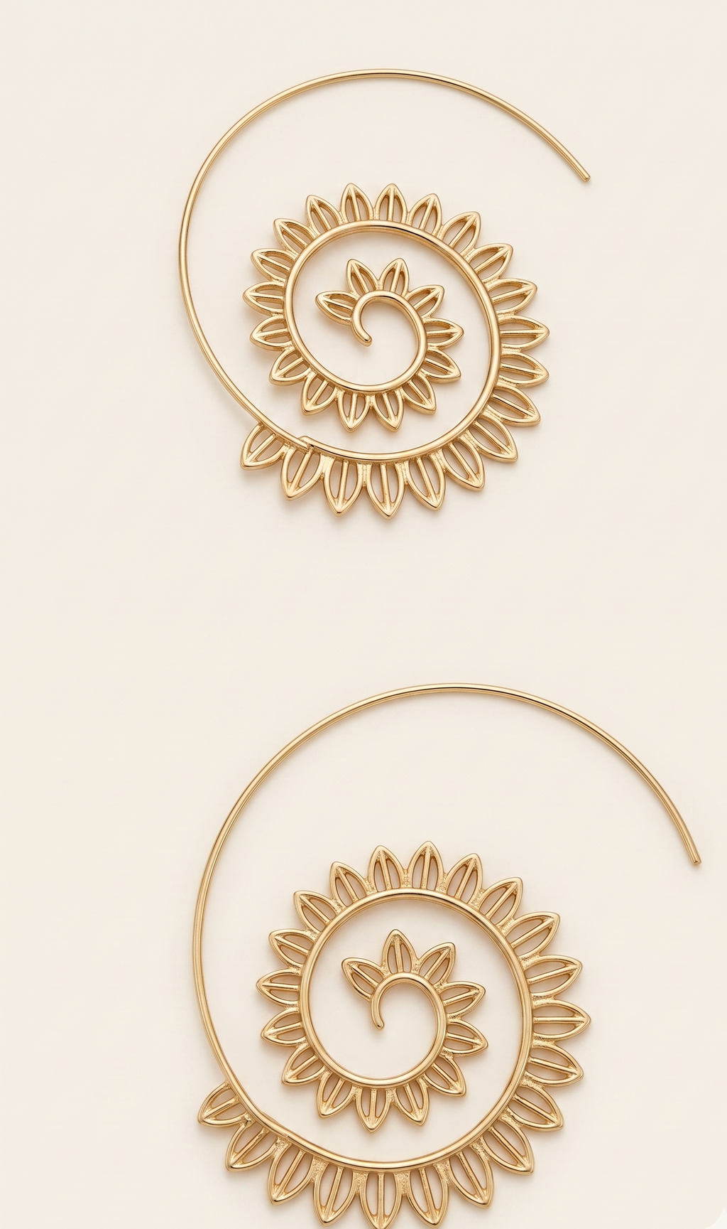 Pair of gold hoop earrings with intricate designs on a beige background