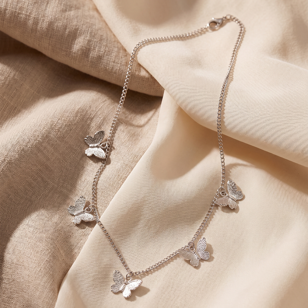 Butterfly-themed necklace on a soft beige fabric background