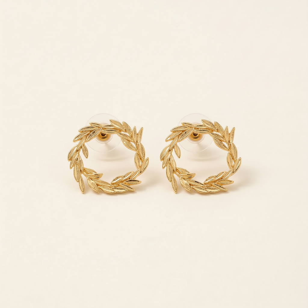 Pair of gold wreath earrings on a beige background