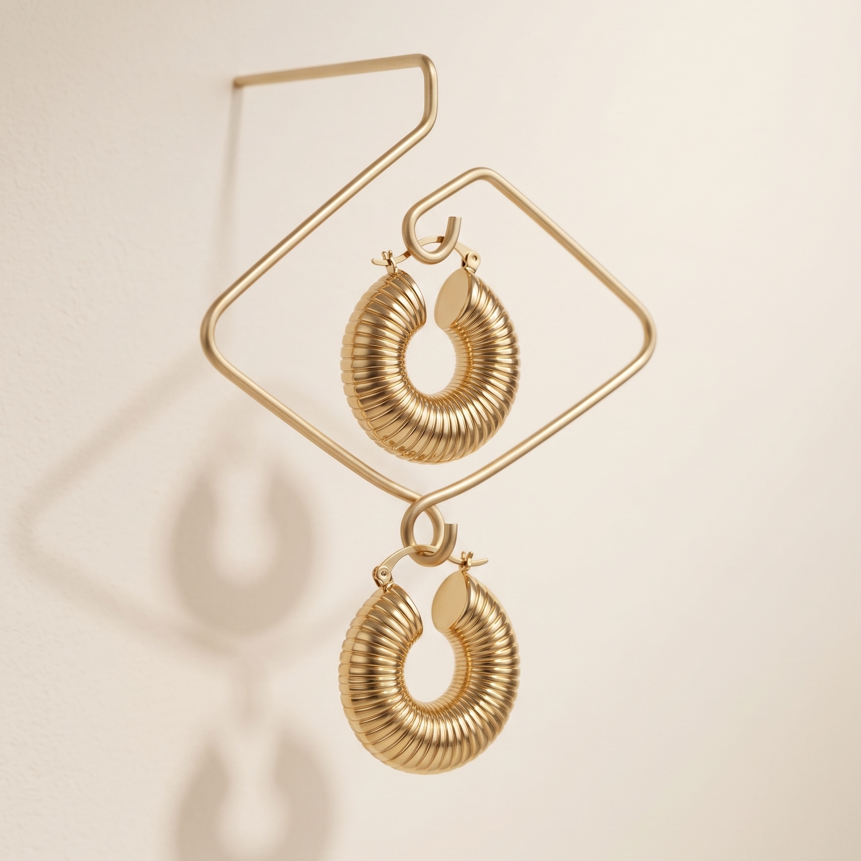Gold hoop earrings on a beige background