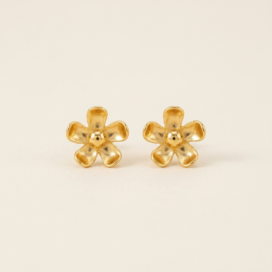 Pair of gold flower-shaped earrings on a beige background