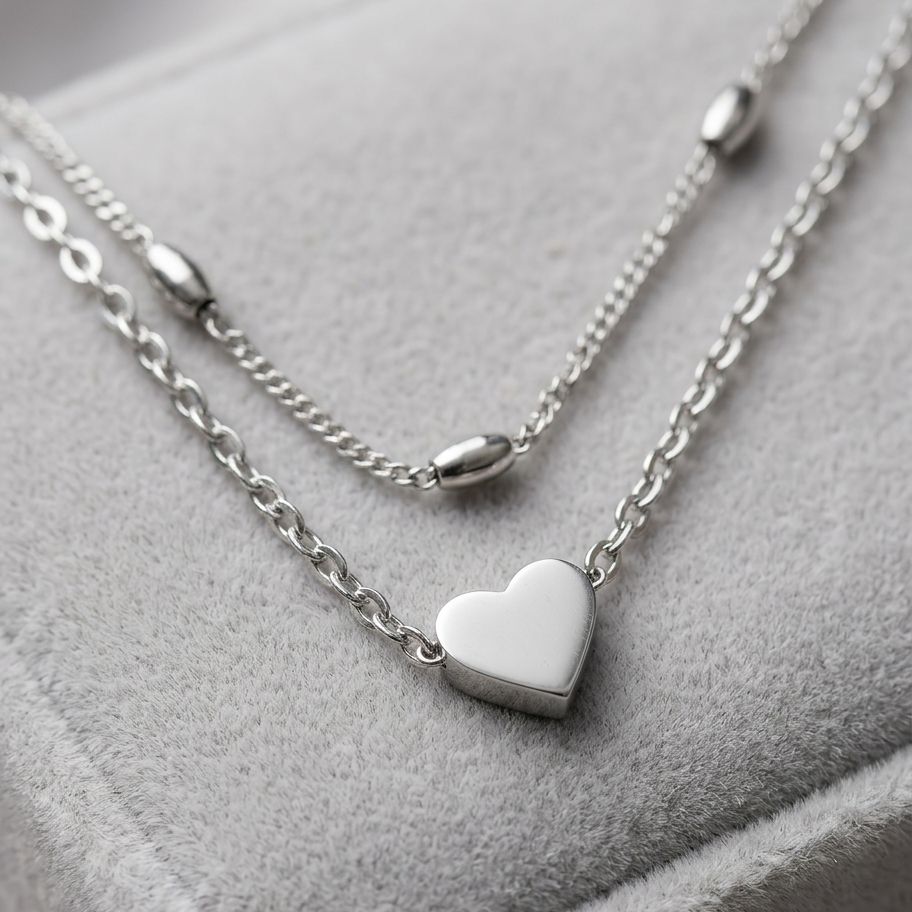 Silver heart-shaped pendant necklace on a soft gray surface