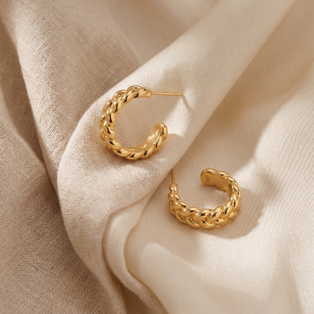 Gold hoop earrings on beige fabric