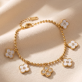 Gold bracelet with floral charms on a beige fabric background