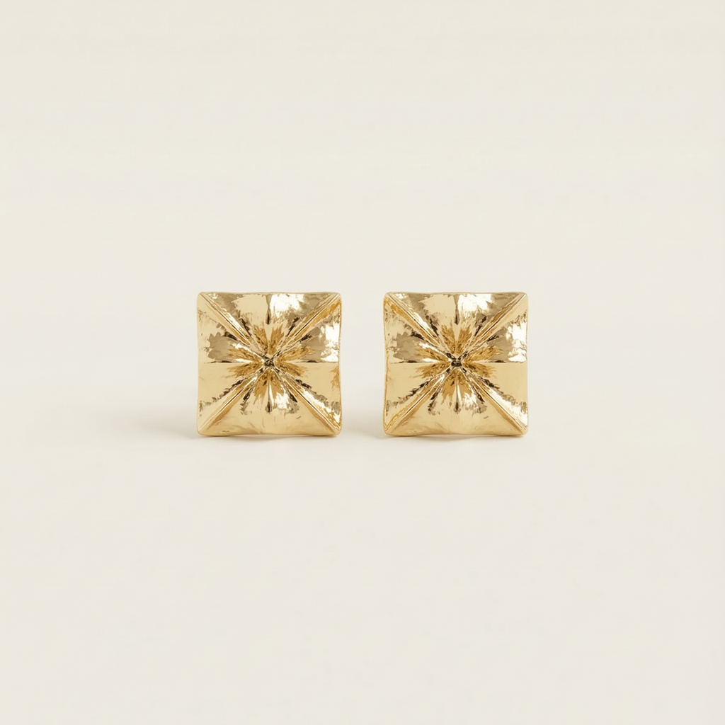 Pair of gold square stud earrings on a light beige background