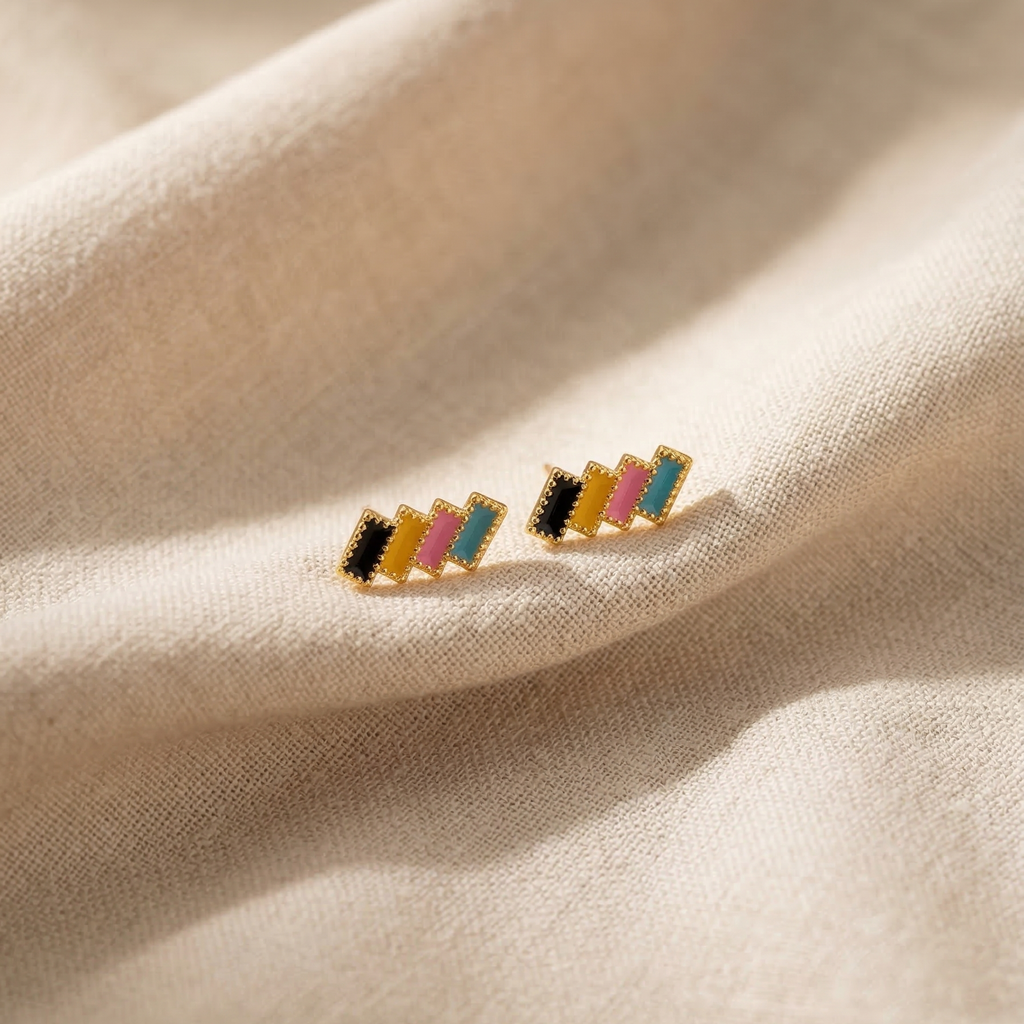Multicolored striped earrings on a beige fabric background