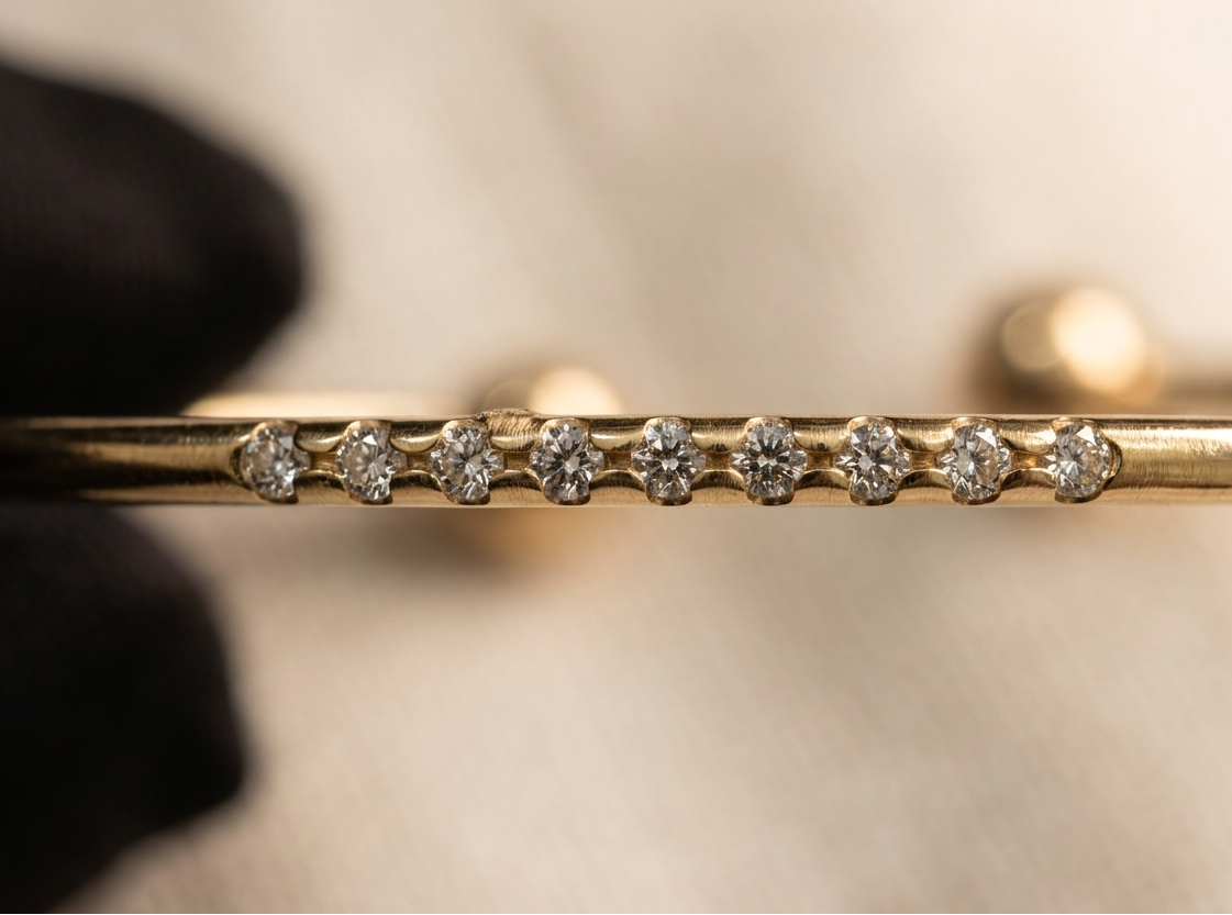 Gold bracelet with diamond accents on a neutral background