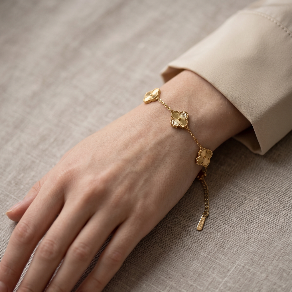 Gold bracelet on a hand with a beige background