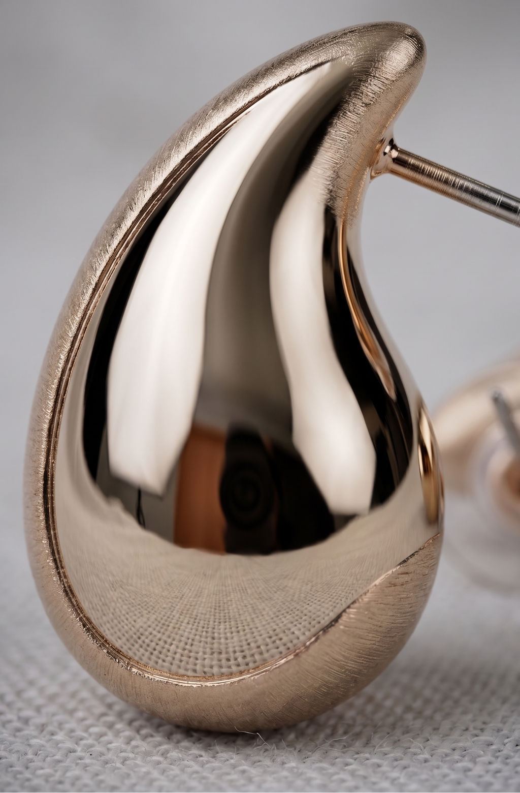Rose gold hoop earring on a gray background