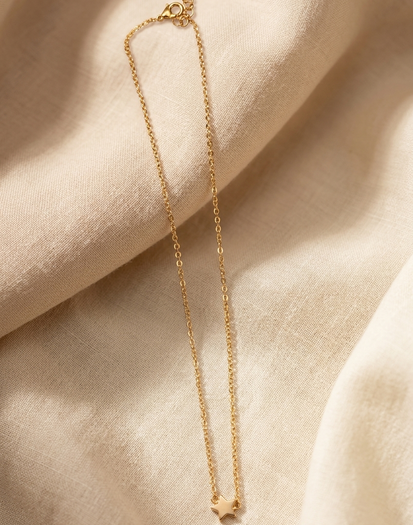Gold necklace on a beige fabric background