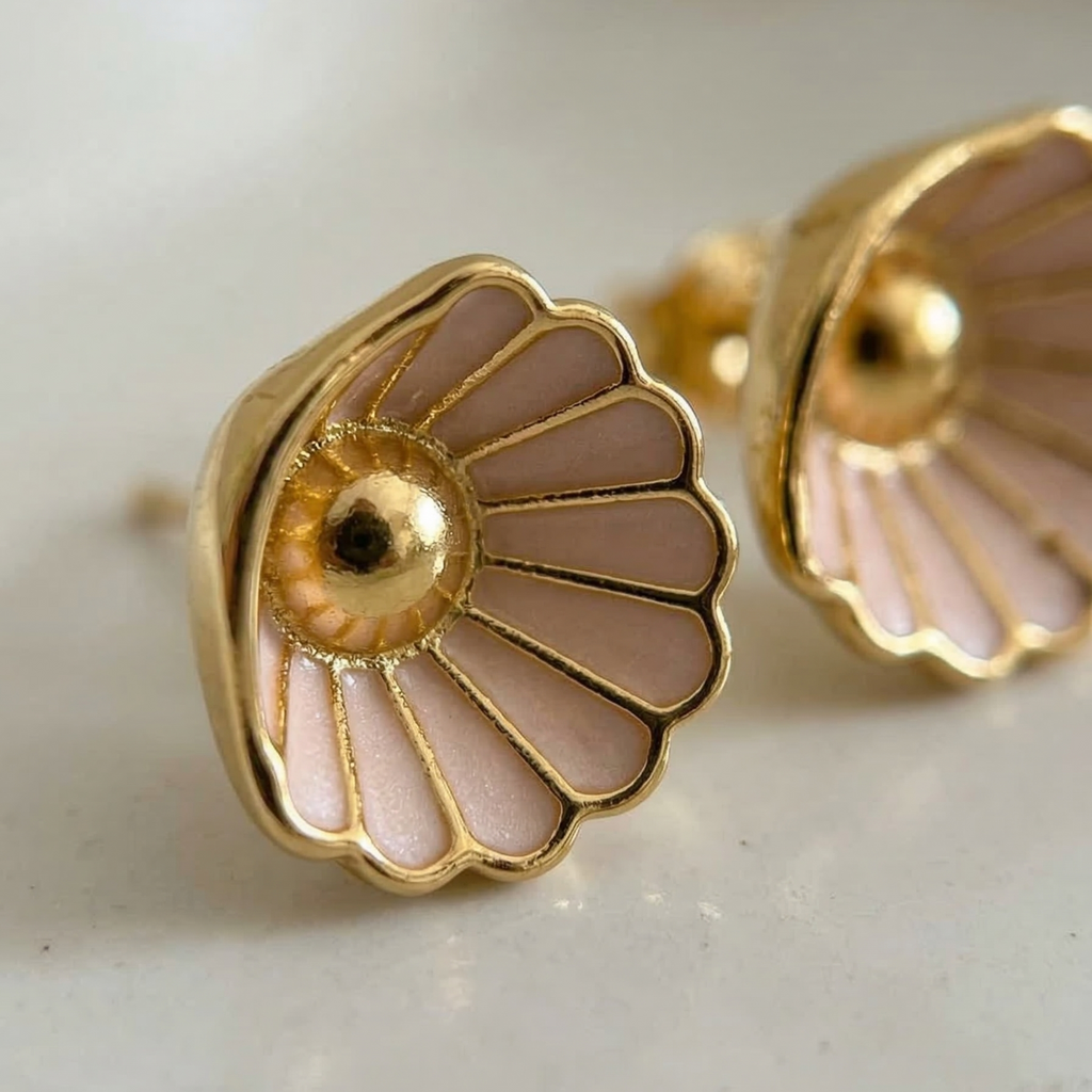 Gold and pink floral earrings on a light background