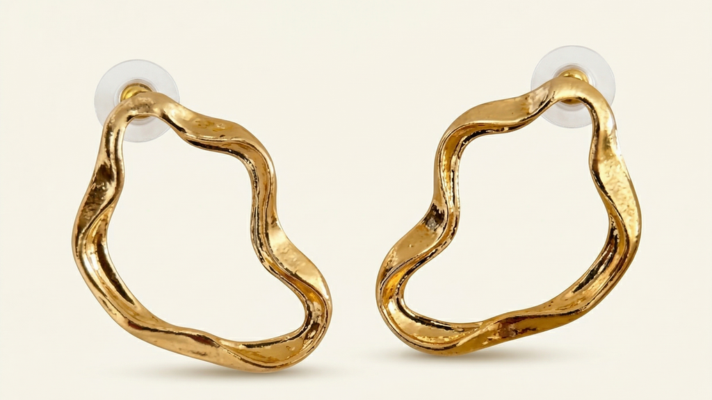 Gold hoop earrings on a light beige background