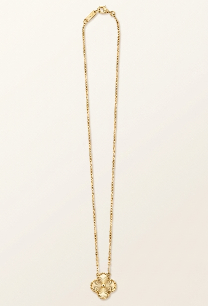 Gold necklace with a pendant on a light beige background