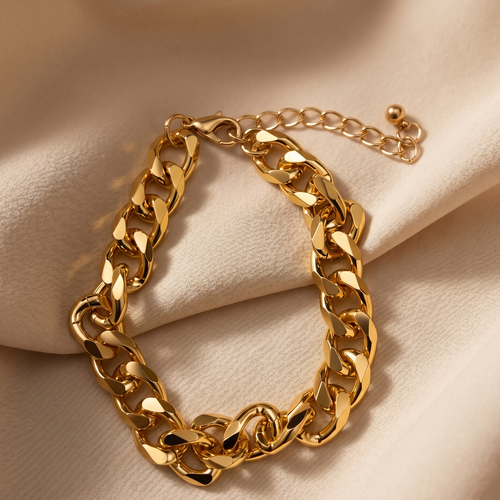 Gold chain bracelet on a beige fabric background