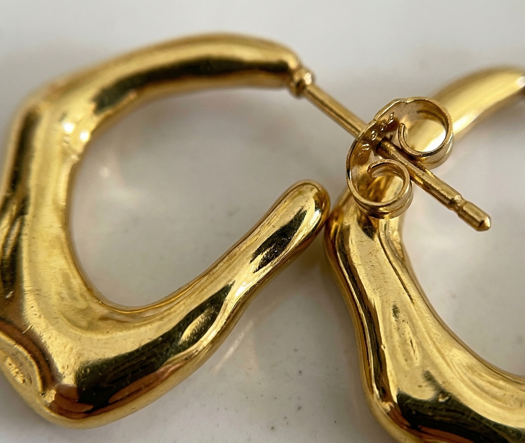 Gold hoop earrings on a light background