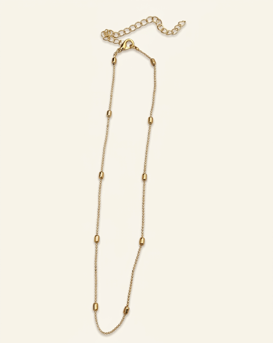 Gold chain necklace on a light beige background