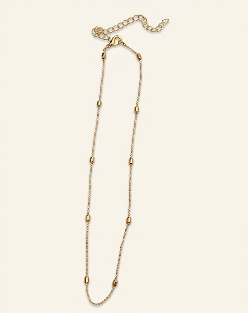 Gold chain necklace on a light beige background