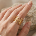 Gold chain ring on a hand with a neutral background