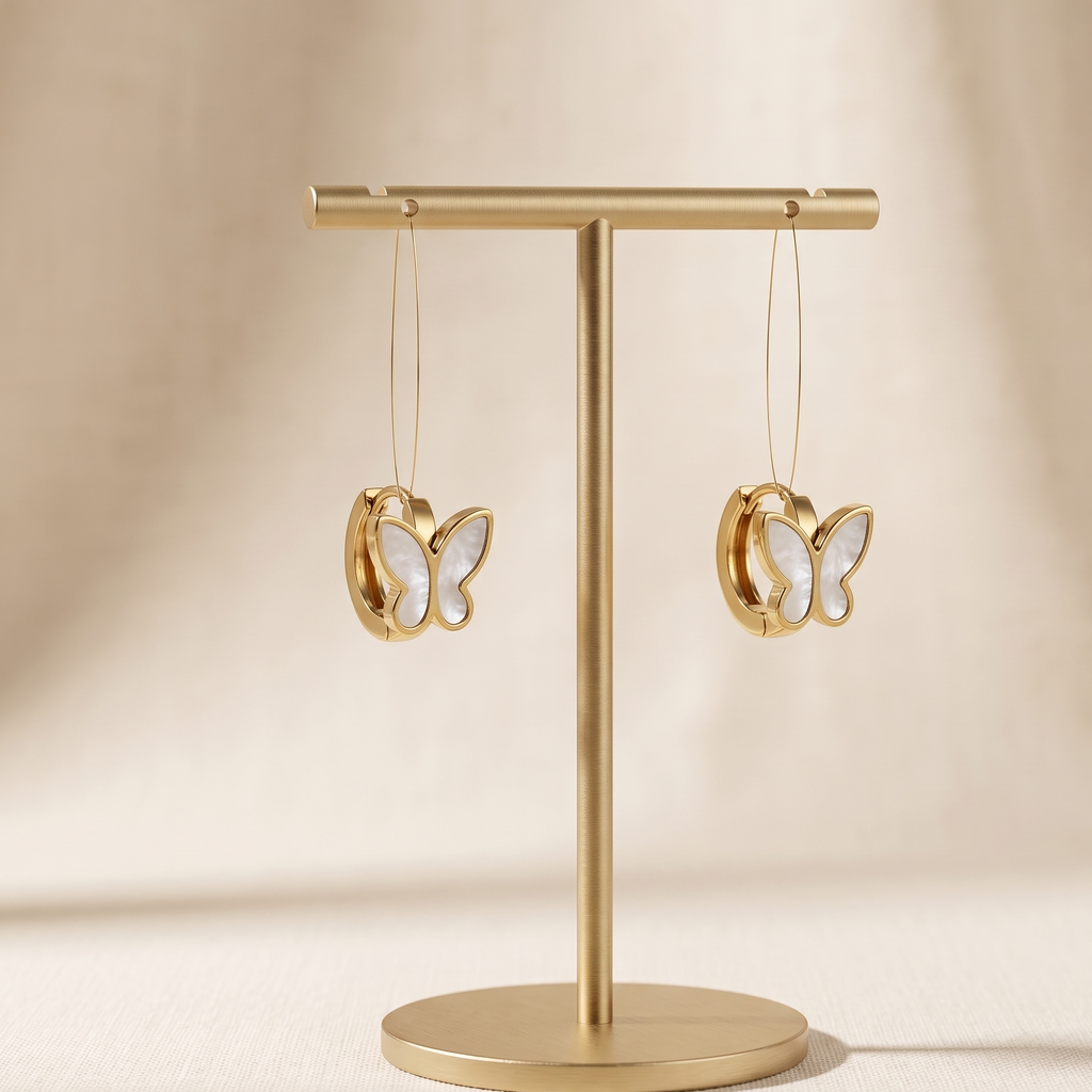 Gold earring stand with butterfly-shaped earrings on a beige background