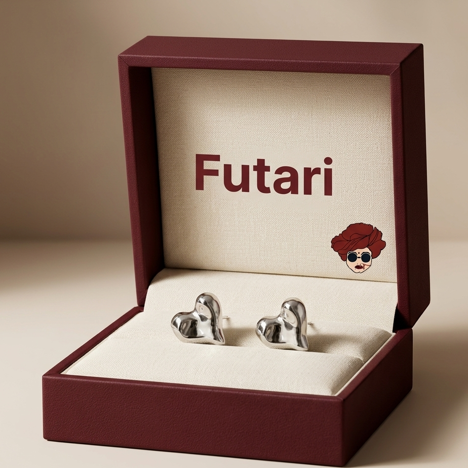 Silver heart-shaped earrings in an open maroon box with 'Futari' branding.
