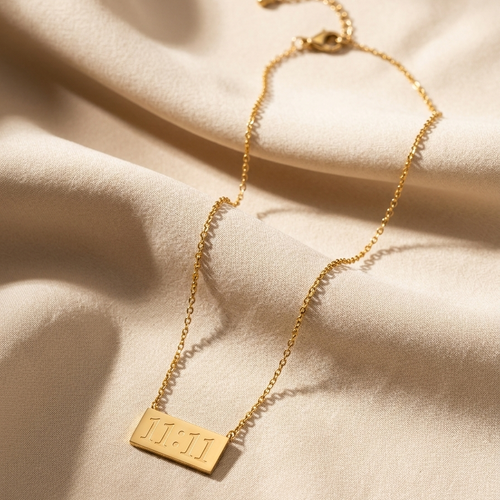 Gold necklace with a tag on a beige fabric background